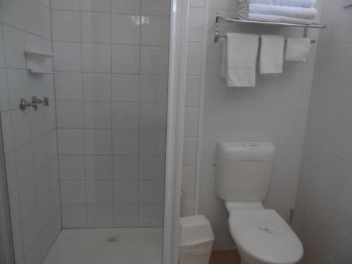 吉朗东部沙滩中心酒店的浴室设有卫生间和带毛巾的淋浴。