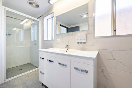 达博Comfort Inn Shearing Shed的白色的浴室设有水槽和淋浴。