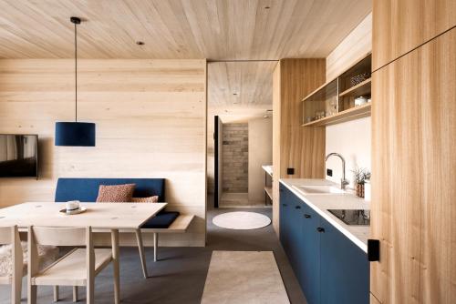 埃格Fuchsegg Eco Lodge的厨房以及带桌子和蓝色橱柜的用餐室。