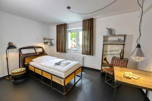 埃森Hostel am Niederfeldsee的一间卧室配有一张床、一张桌子和一张桌子