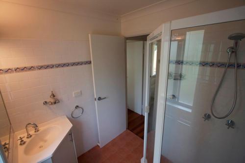 拜伦湾Byron Bay Accom Unit 3 41 Childe Street - Belongil Beach Apartment的带淋浴、盥洗盆和淋浴的浴室