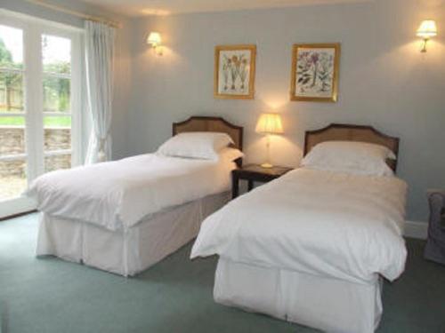 赛伦塞斯特Well Cottage B and B的一间卧室设有两张床和窗户。