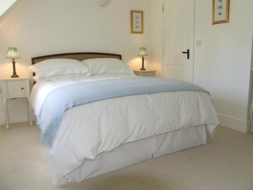 赛伦塞斯特Well Cottage B and B的卧室配有一张带白色床单和枕头的大床。