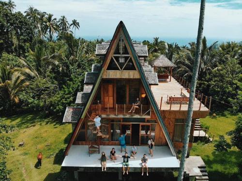 曼巴豪Camiguin Volcano Houses - A-Frame house的一群站在房子外的人