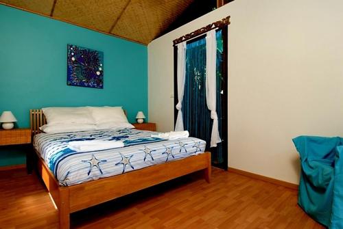 拜伦湾Byron Bay Accom 2B Manfred St - The Wave House的一间卧室配有一张蓝色墙壁的床和一扇窗户