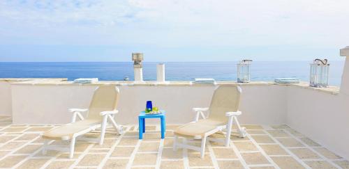 维拉诺瓦Casa Corallo的阳台上配有两把椅子和一张桌子,享有海景