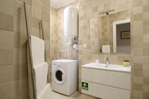里斯本Flats Castelo - HOrigem的一间带洗衣机和水槽的浴室