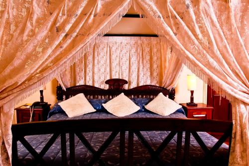 科伦坡东方大酒店的卧室配有带枕头的天蓬床