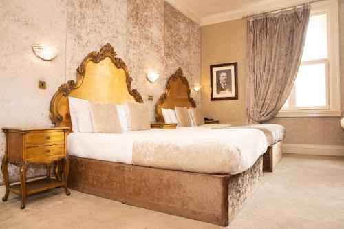 利物浦30詹姆斯街酒店的一间大卧室,配有一张大床和一个窗户