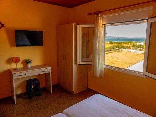 奥马斯帕纳吉亚斯Ktima Argiri的一间卧室配有一张床,窗户配有书桌