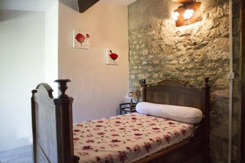 SenouillacCHEZ SIMONE的一间卧室设有一张床和石墙