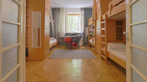 斯普利特Tchaikovsky Hostel Split (T-Hostel)的一间带书桌的房间和一间带双层床的房间