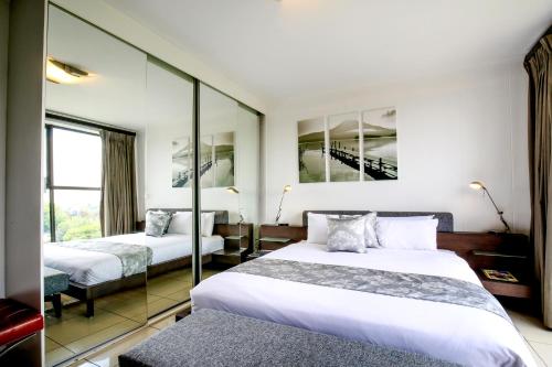 约翰内斯堡尼科尔公寓式酒店的酒店客房,设有两张床和镜子