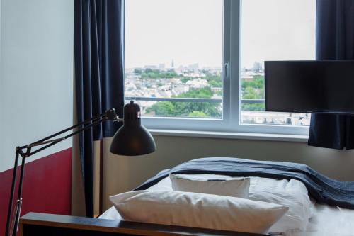 汉堡Base Apartments的一间卧室设有一张床和一个大窗户