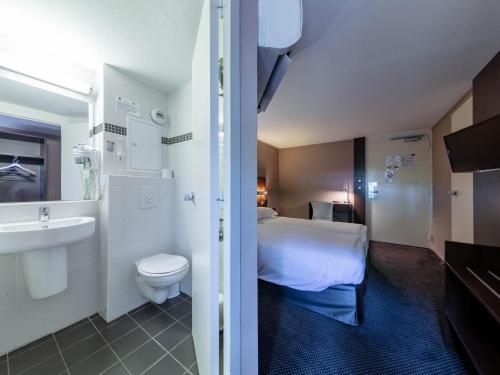 瓦朗斯堡Noemys Valence Nord - hotel restaurant的浴室设有床、卫生间和水槽。
