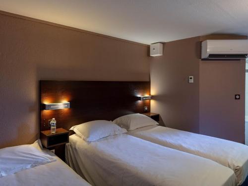 瓦朗斯堡Noemys Valence Nord - hotel restaurant的配有白色床单的酒店客房内的两张床