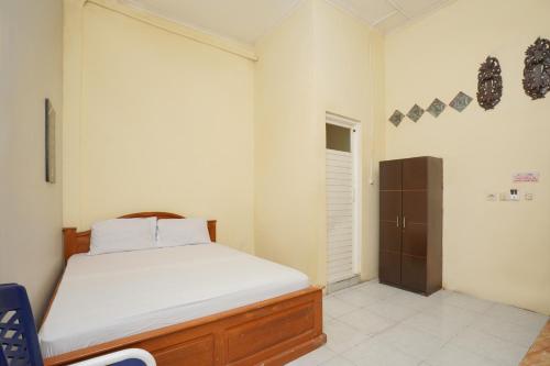 诗都阿佐KoolKost Syariah near T1 Juanda Airport 3的一间卧室配有一张床和一个衣柜