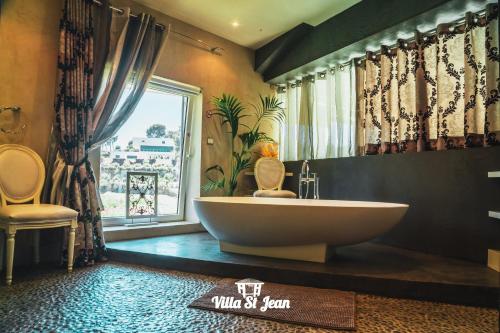 拉西约塔Villa St Jean SUITE Romantique的一间带大浴缸和窗户的浴室
