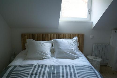 里尔拉考尔苏博思品酒店的一张带白色枕头的床和一个窗户