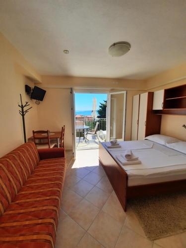 普罗马尼亚Palma Promajna Apartments的一间卧室设有一张沙发和一张美景床。