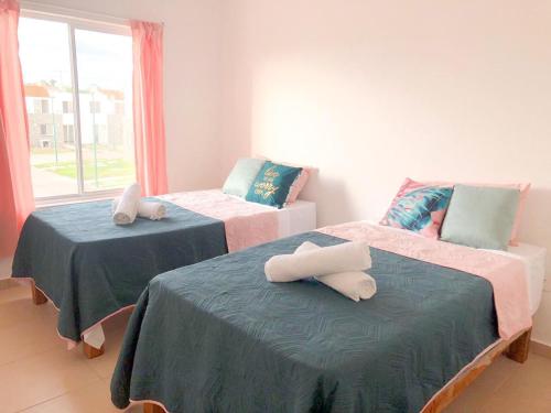 巴亚尔塔港Modern Pool Side 3 Bedroom House, Puerto Vallarta的客房内的两张床和毛巾