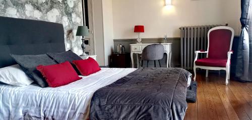 波旁朗西Logis Hotel La Tourelle du Beffroi的一间卧室配有一张带红色枕头的大床