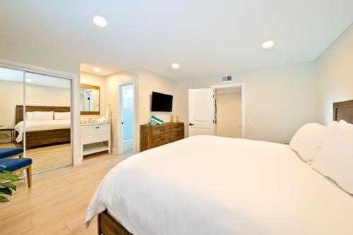 纽波特海滩Newport Beach Condo Deluxe I & II的卧室配有一张白色大床和电视。