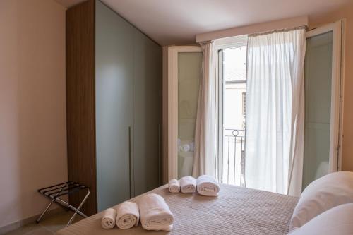 波尔图圣乔治B&B Borgo Marinaro的卧室配有带窗户的床上的2双拖鞋