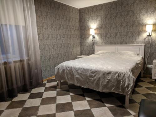 奥泰佩瑞迪别墅酒店的一间卧室配有一张床,铺有一个 ⁇ 板地板