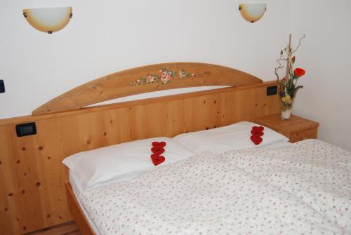 维哥迪法萨Residence Ciasa Alpe的枕头上带红色弹夹的床