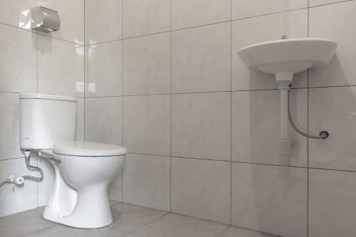 JembranaHotel Niki的白色的浴室设有卫生间和水槽。