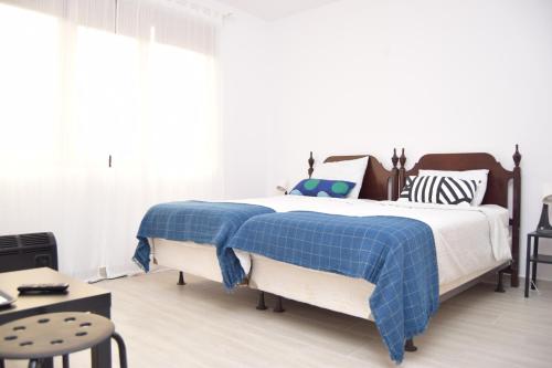 沃伦塔里Hotel Road Rooms的一间卧室配有一张带蓝色铺面毯子的床