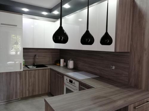科沃布热格Apartament Nadmorski的厨房配有木制橱柜和黑色吊灯
