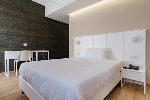 巴里波斯顿酒店的卧室配有一张白色大床和一张书桌