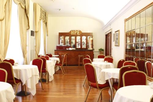 罗马佩斯埃尔维缇亚酒店的一间带桌椅的餐厅和一间酒吧