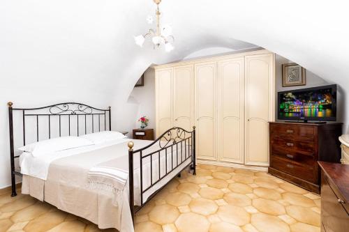 阿特拉尼Il Nido Casa Vacanze的一间卧室配有一张床和一个带电视的梳妆台。