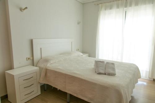 卡尔佩Sotavento Atico Calpe的白色卧室配有带两个枕头的床
