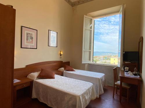 马里纳迪马萨意大利酒店的酒店客房设有两张床和窗户。