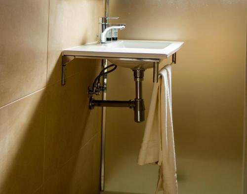 拉曼加戴尔马尔梅纳拉曼加别墅公寓酒店的浴室水槽,下面挂着毛巾
