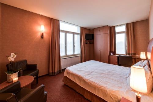 博尔讷姆Hotel De Notelaer的配有一张床和一把椅子的酒店客房