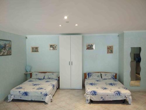 马赛大地之元马赛11°公寓的一间卧室配有两张床和白色橱柜