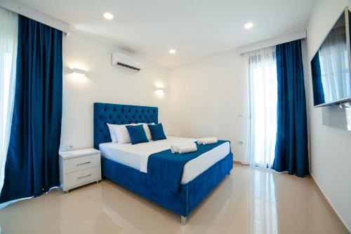 乌尔齐尼Hotel Ambiente Ulcinj的一间卧室配有蓝色的床和蓝色窗帘