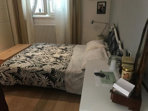 卢卡camera con bagno privato e parcheggio的一张带黑白毯子和桌子的床