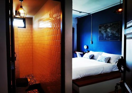 尖竹汶谦婵旅舍的一间卧室设有一张床和蓝色的墙壁