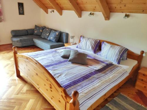 Ebene ReichenauGästehaus Laßnig的一张大木床,位于一个配有沙发的房间