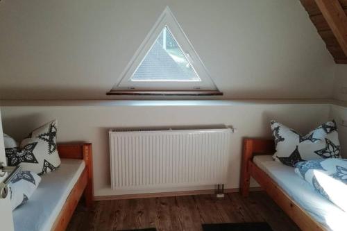 HerrischriedMühlehof的客房设有两张带枕头的床和窗户。