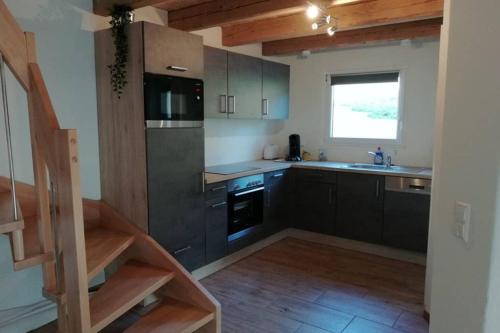 HerrischriedMühlehof的厨房配有黑色橱柜和水槽