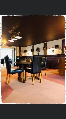 GorronHôtel le Bretagne et Restaurant Le Papillon的一间用餐室,配有黑色椅子和桌子