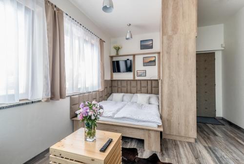 捷克布杰约维采Modern fully equipped studio with parking Zavadilka 2620的一间设有床铺和鲜花桌的房间