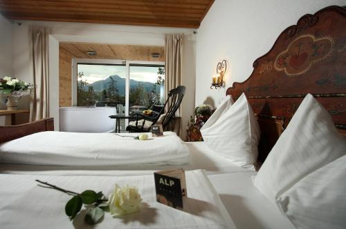 因斯布鲁克格森斯阿尔卑斯艺术酒店的酒店客房带两张床、椅子和窗户